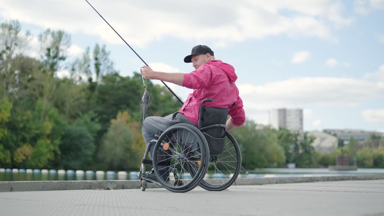 persona con discapacidad física que utiliza silla de ruedas para pescar en el muelle de pesca
