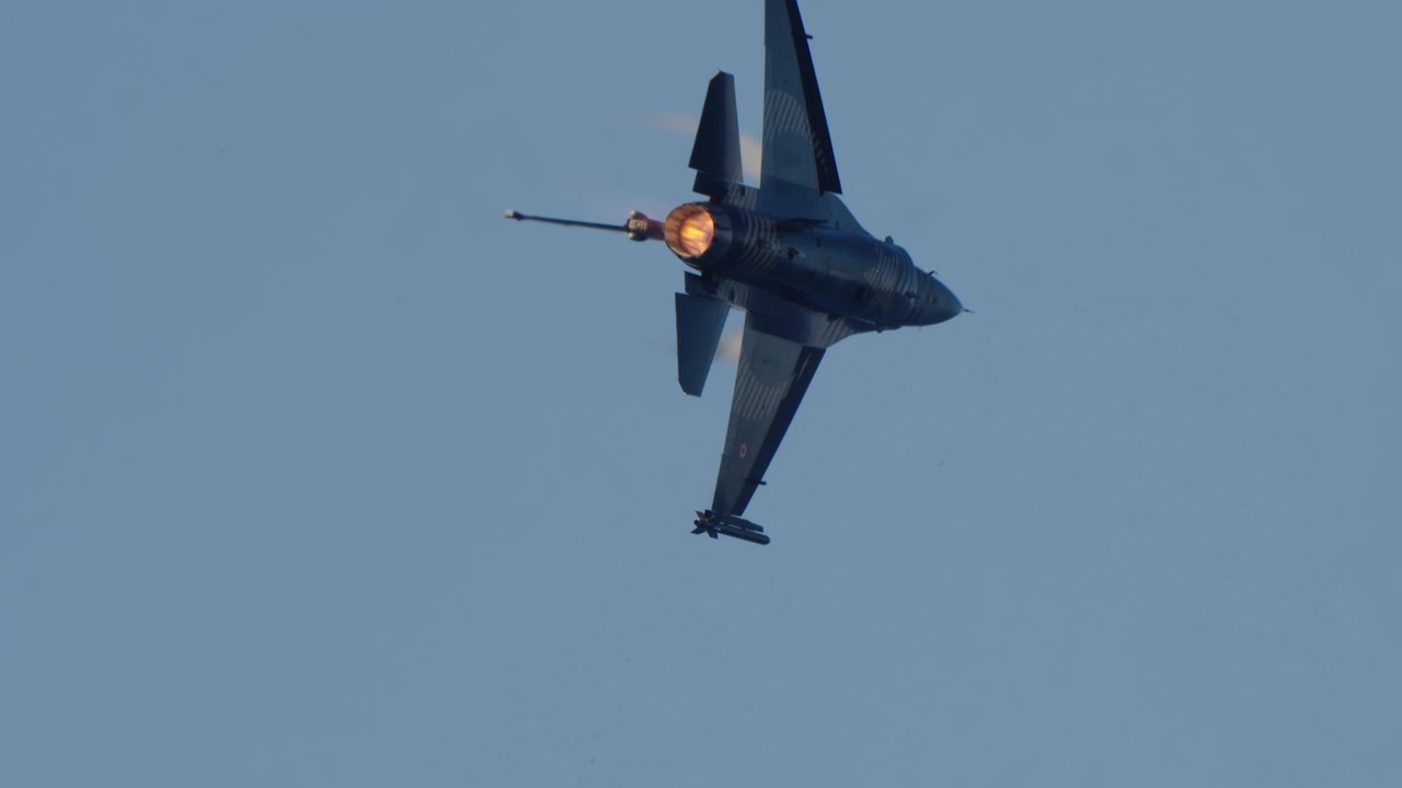 Powerful F-16 Fighter Jet Flying with Afterburner in Blue Sky