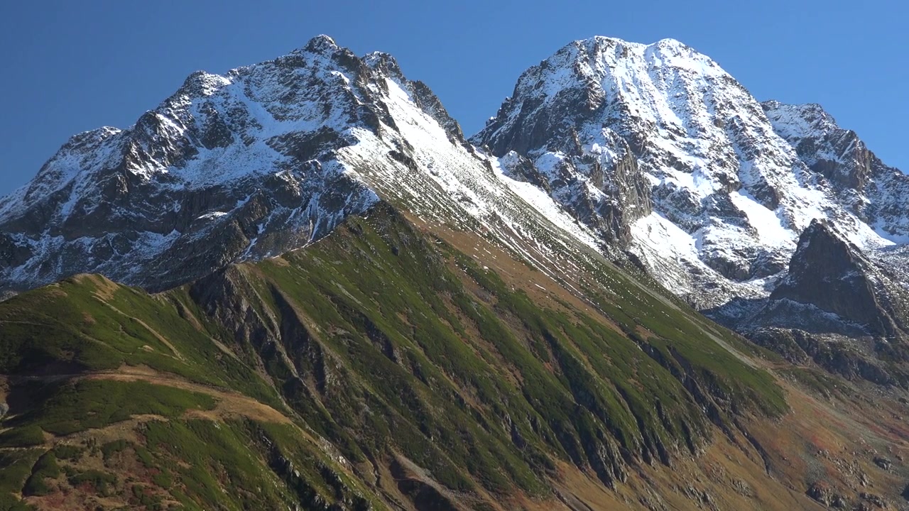 Snow-Capped Mountain Peaks Against a Clear Blue Sky