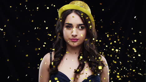 mujer con sombrero amarillo de fiesta con confeti dorado