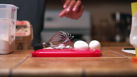 el joven coloca huevos en el mostrador mientras se prepara para preparar el desayuno para la familia