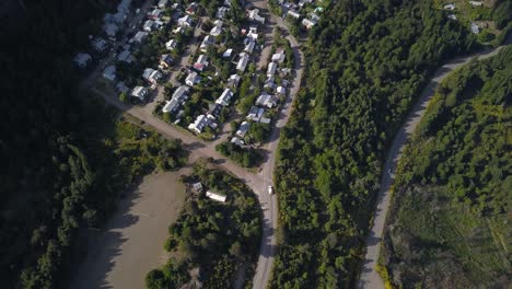 Aerial-top-down-view-over-cars-driving-on-countryside-roads-amidst-dense-greenery