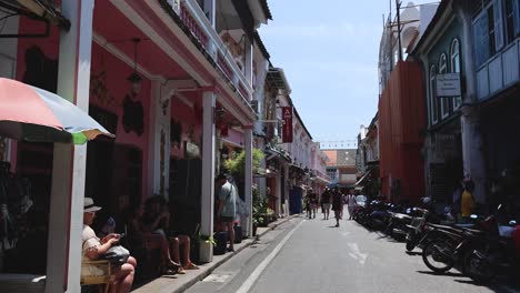 pedestrians and vendors on a sunny market street