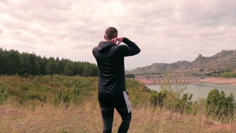 man arriving at an edge of a forest watching the landscape in front of him