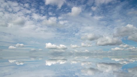 futuristic background consisting of time lapse clip of white fluffy clouds over blue sky and their reflection, video loop