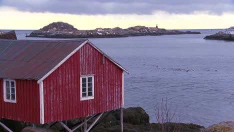 Red-huts-line-a-harbor-and-bay-in-a-village-in-the-Arctic-Lofoten-Islands-Norway