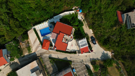 Top-down-drone-shot-rotating-above-a-luxury-villa-in-the-hills-of-sunny-Montenegro