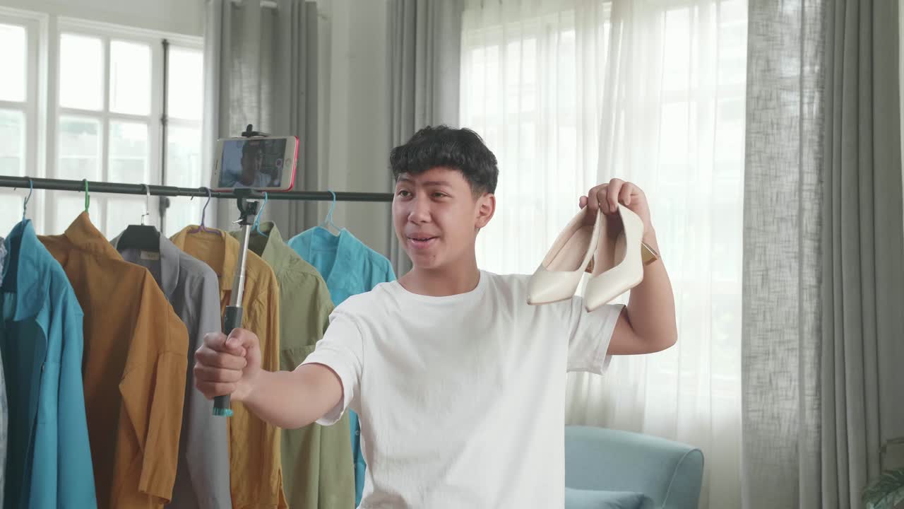 Asian Man Online Seller Recommending Kitten Heels And Recording Video By Mobile Phone While Selling Shoes At Home