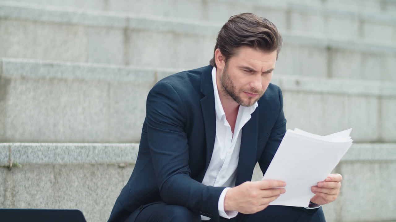 Business man working with documents on street. Businessman looking at graphs