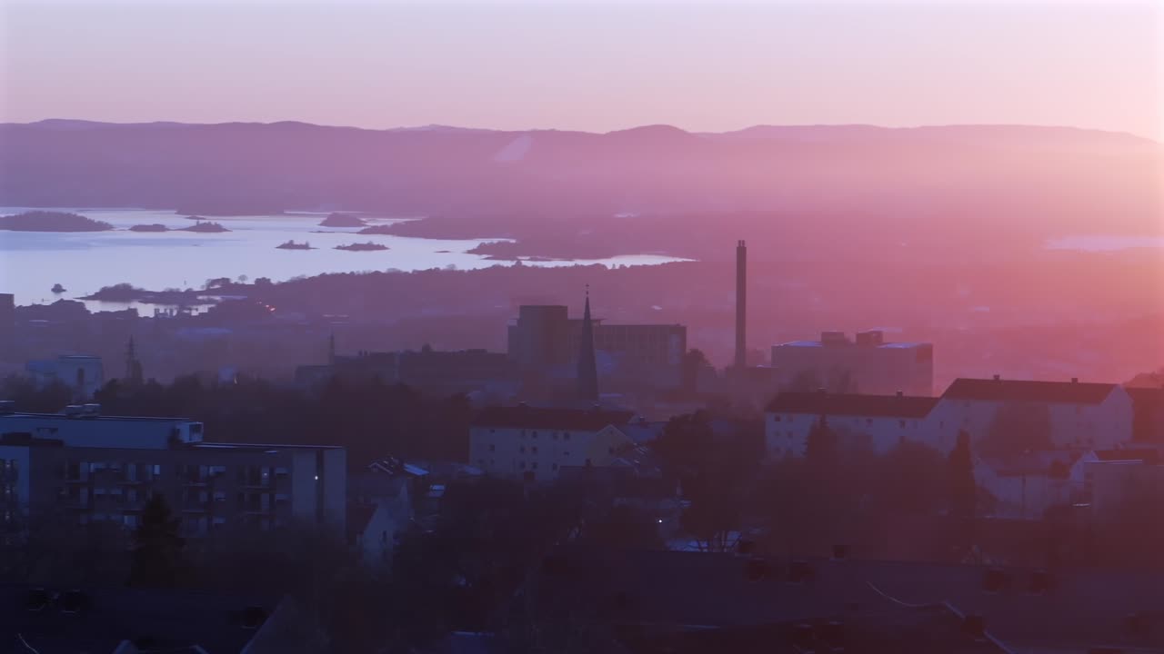 Norwegian vibrant pink purple huesunset Oslofjord Olso city Norway Norge aerial drone inner coastline Hovedøya Lindøya island church apartment buildings downtown cityscape circle right
