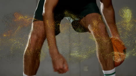 basketball player dribbling ball with golden particles animation over legs