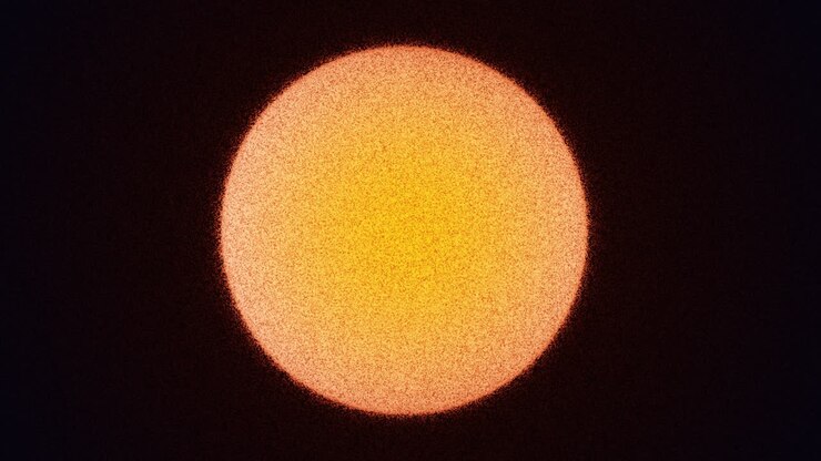 Abstract Grainy Orange Sphere Moving Across Dark Background