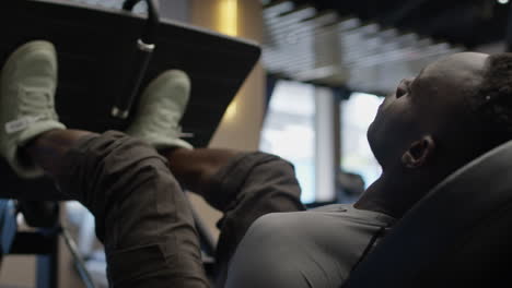 man using a leg press machine in a gym