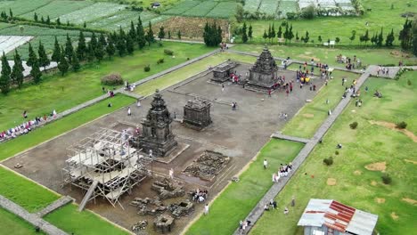 Ancient-stone-temple-visited-by-tourists-in-Indonesia,-aerial-view