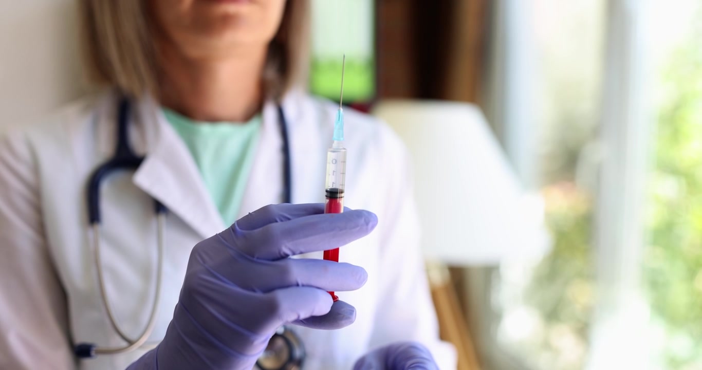 A healthcare professional carefully prepares a vaccine with a syringe for administration
