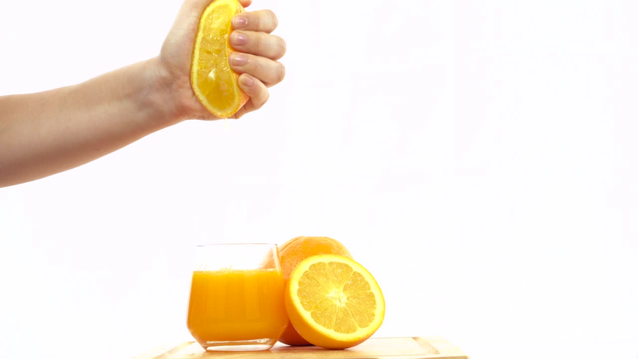 Naranja fresca exprimida a mano en un vaso de zumo de naranja