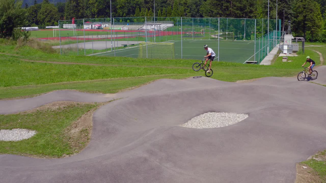 Group of young bikers and scooter speed at pump track. Extreme sports