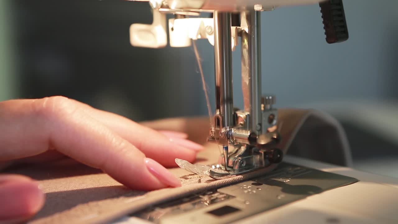 Home Craft. Woman is Sewing. Seamstress work on the sewing machine at home