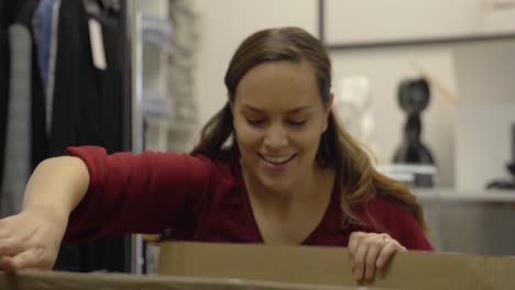 woman happy about opening up a box and finding contents