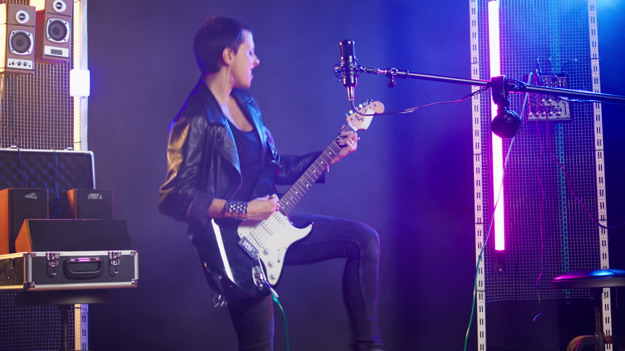 Woman performing live music with electric guitar and microphone on stage