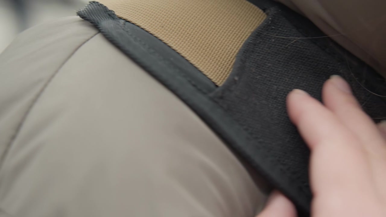 Test dell'imbottitura dello zaino per il comfort. Un influencer esamina l'imbottitura degli spallacci per verificarne la durata e la sensazione al tatto. Primo piano di un influencer che testa la qualità tattile e la durata dell'imbottitura degli spallacci dello zaino
