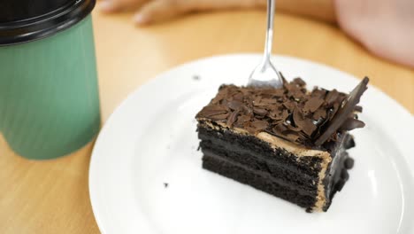 hand with a spoon eating chocolate cake ,