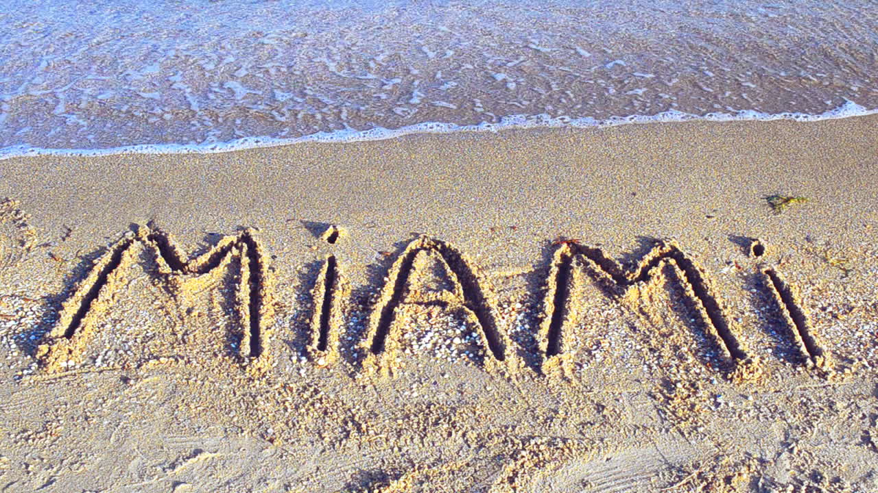 Indskriften "Miami" i sandet. Indskrift på sand
