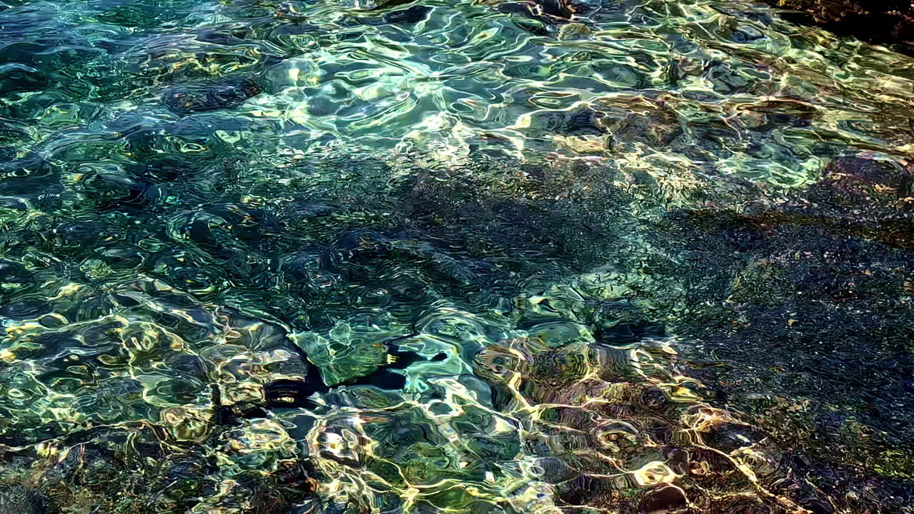 L'acqua limpida increspa le rocce a Omprogialos, in Grecia, in un'atmosfera pacifica e serena