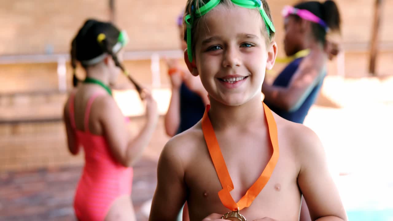 retrato de un niño feliz mostrando su medalla de oro y gesticulando