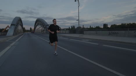 an athlete goes running, jogging on a bridge on the main in frankfurt