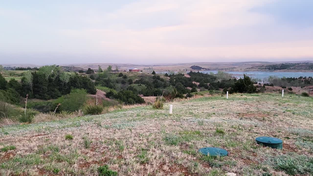 tormenta de viento con vistas al lago y al campo de hierba en texas con nubes en el campo, colinas y árboles