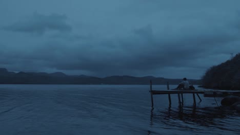 scenic timelapse young man enjoying view within nature on dock zoom in