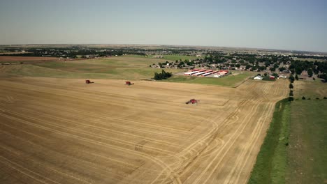 Drone-shot-of-a-farming-combine-harvesting-the-wheat-in-a-large-agricultural-field