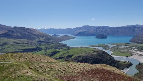 Ein-Schwenkblick-Auf-Die-Malerische-Aussicht-Vom-Gipfel-Des-Felsigen-Berges-Nach-Einer-Wanderung-Zum-Gipfel-An-Einem-Wunderschönen,-Klaren-Frühlingstag-In-Wanaka,-Neuseeland