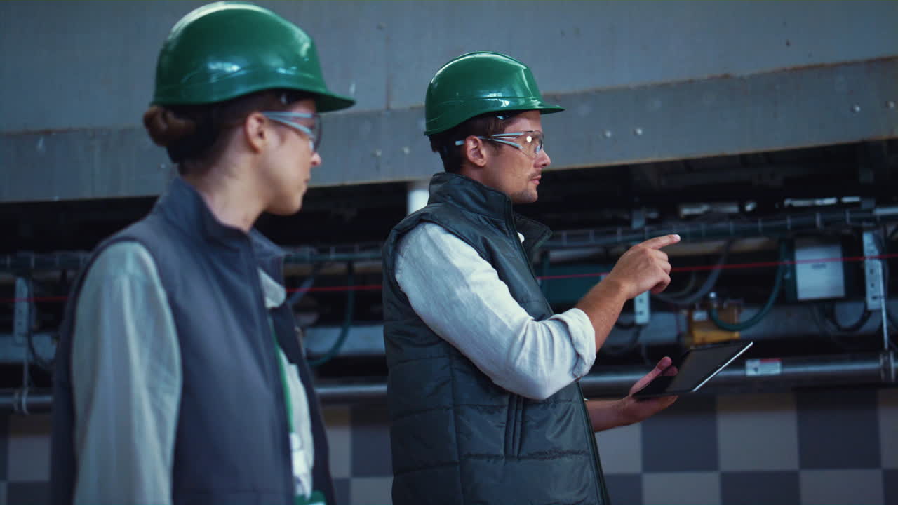 Agriculture supervisors inspecting manufacture facility together in uniform.
