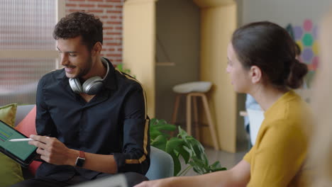 joven empresario usando una tableta que muestra las ideas de negocio del cliente apuntando a la pantalla empresarios trabajando juntos haciendo lluvia de ideas disfrutando de la conexión de trabajo en equipo en una oficina moderna
