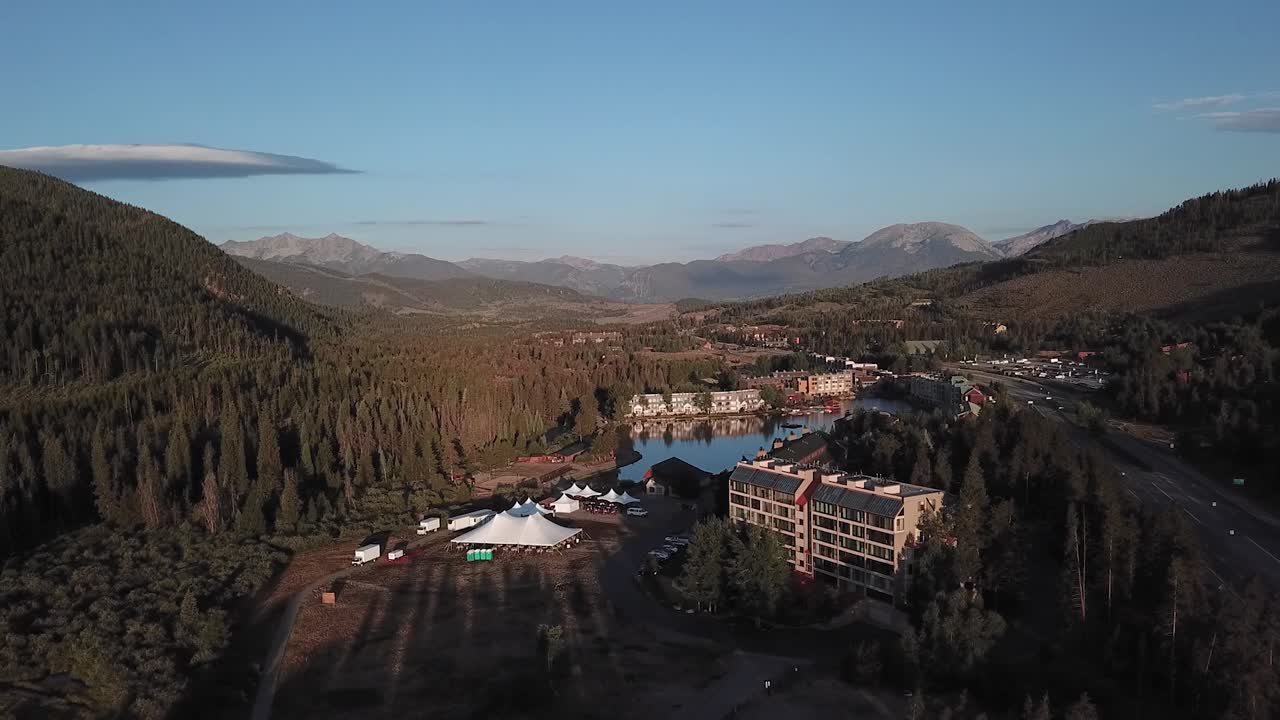 Panning aerial view of the beautiful Keystone resort and lake at sunset in Colorado