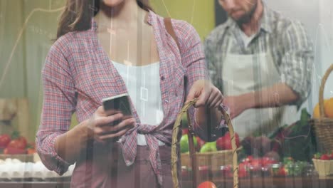 animation of statistics and financial data processing over caucasian woman using smartphone in shop