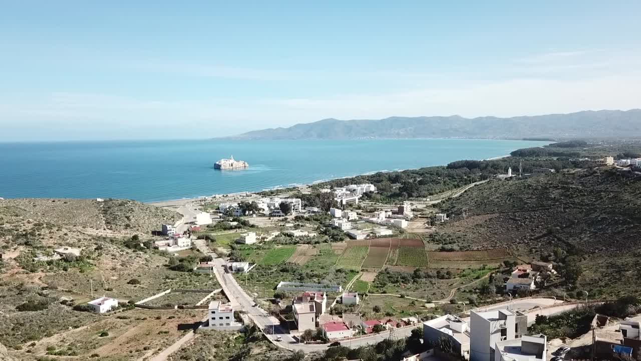 Breathtaking wide-angle drone shot capturing the vast Rif Mountain range stretching along the deep blue Mediterranean coastline in Northern Morocco