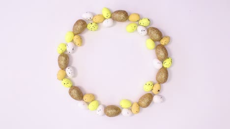 copiar el círculo de espacio creativo hecho de oro, huevos amarillos y blancos en movimiento.