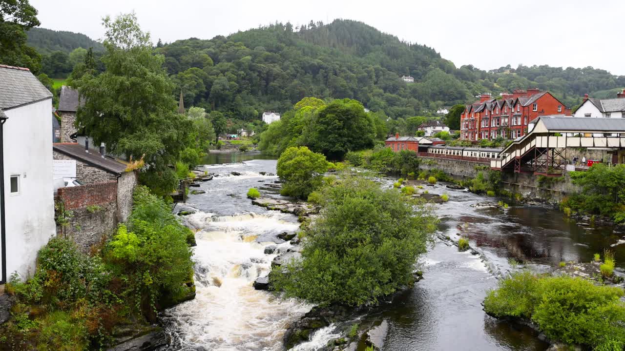 Fiume che scorre con edifici e vegetazione