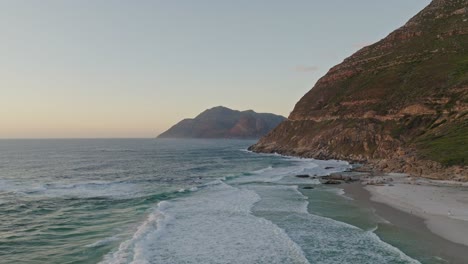 Drone-shot-of-the-cliffs-where-the-Chapmans-peak-route-starts,-during-sunset