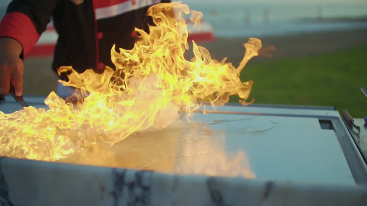 Chef preparing teppanyaki on a beach grill