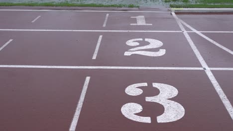 rainy day, athletics track in the stadium.t he ground is marked with runways 1 to 3.