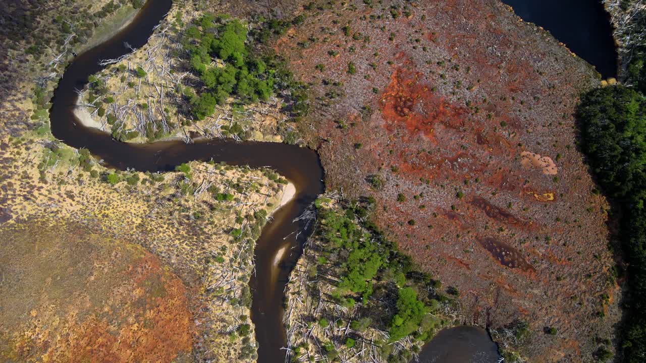 drone disparado volando sobre el río larsiparsabk en tierra del fuego, argentina mientras panorámica para revelar las montañas de los andes