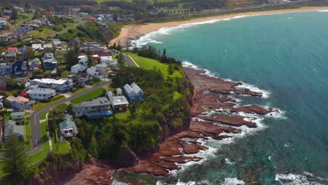 vista aérea de hermosos edificios en la península de pheasant point con vista a la playa de bombo en kiama, nsw, australia