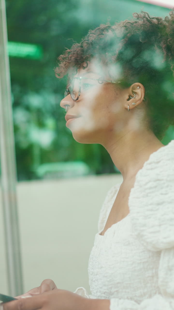 Woman with curly hair smoking indoors