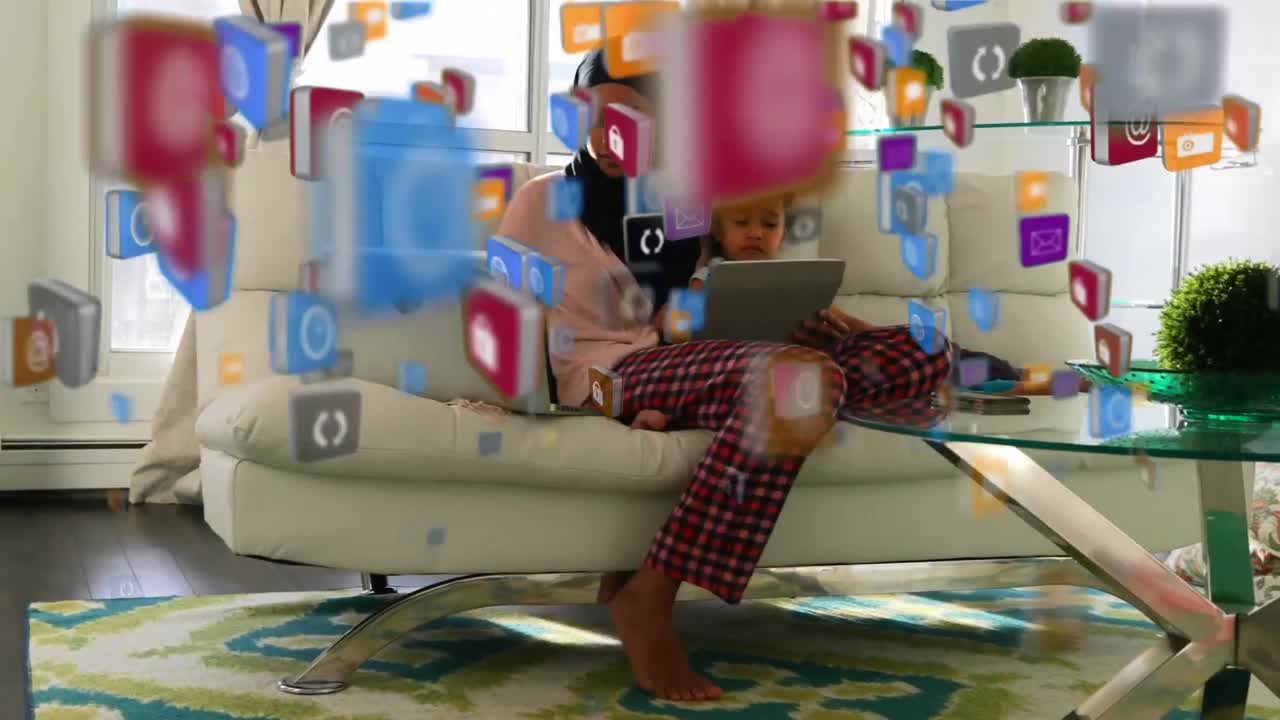 iconos digitales moviéndose contra la madre usando computadora portátil y la hija usando tableta digital
