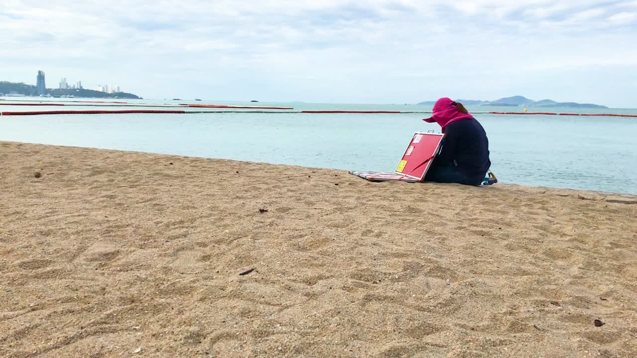 정체 불명의 복권 판매자가 태국 파타야 해변에 홀로 앉아 고객을 기다리고 있습니다.