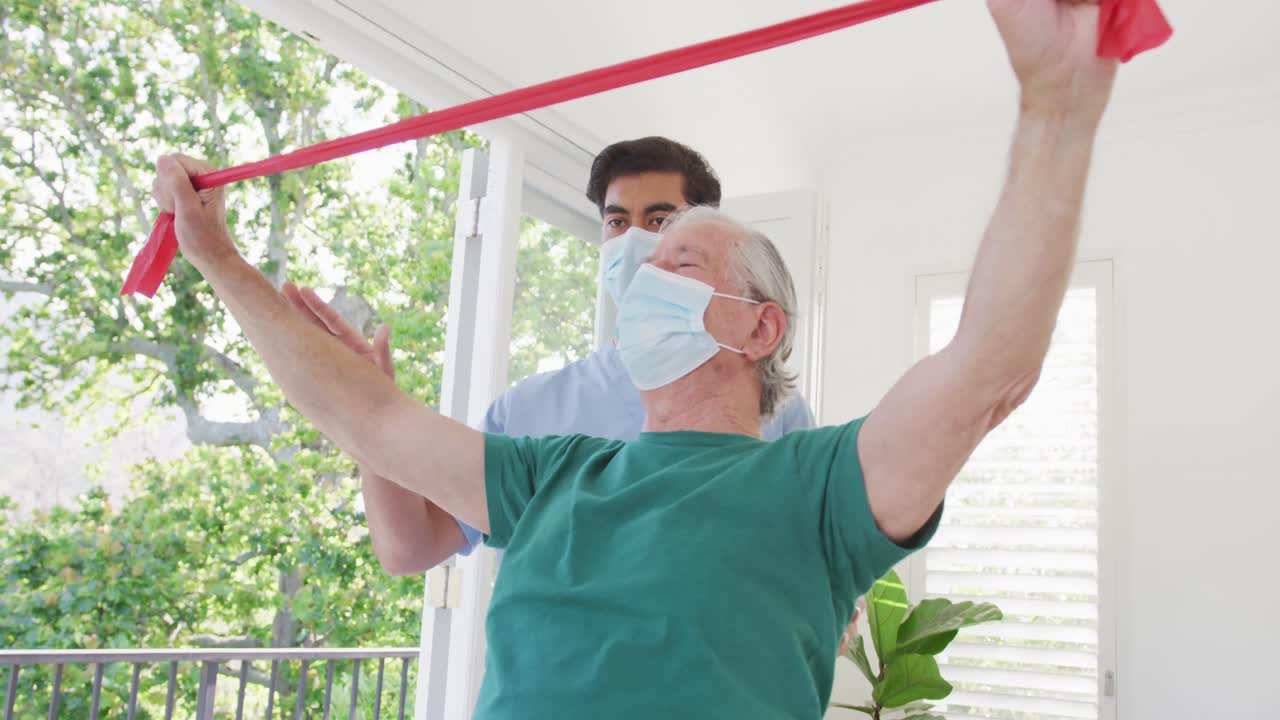 코로나19 기간 동안 요양원에서 운동하는 동안 얼굴 마스크를 착용하는 남성 치료사와 노인